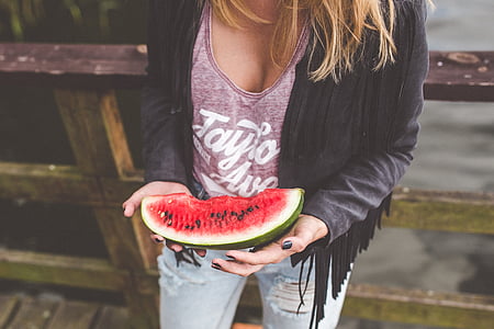 person standing holding sliced watermelon thumbnail