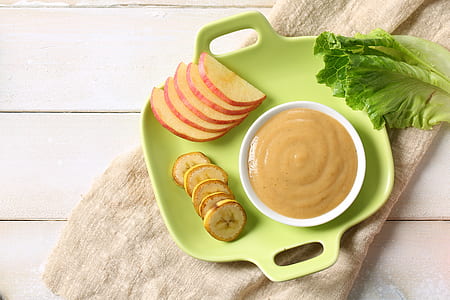 gravy on white ceramic saucer beside slice fruits on green plastic tray thumbnail