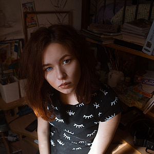 close up photo of woman with black and white shirt sitting on brown wooden desk thumbnail