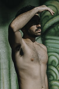 topless man standing while hiding face thumbnail