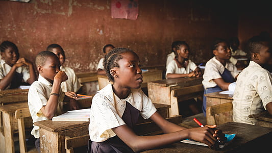 child in white and black short-sleeved dress sitting in front of desk thumbnail