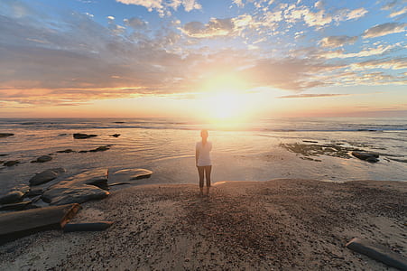 person standing on shore during golden hour thumbnail