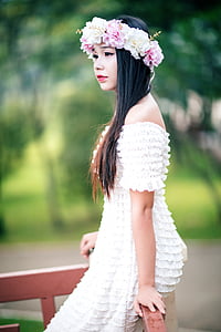 woman wearing white ruffled off-shoulder dress sitting on brown wooden fence thumbnail