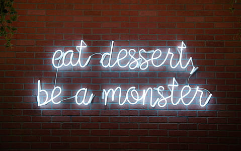 white eat desserts be a monster neon light signage on brown brick wall thumbnail