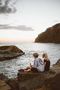 man and woman sitting on cliff thumbnail