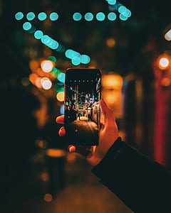 person holding smartphone taking photo of alleyway thumbnail