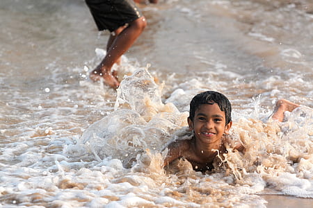 boy lying on shore taken during daytime thumbnail