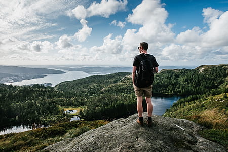 man wearing black t-shirt standing on cliff thumbnail