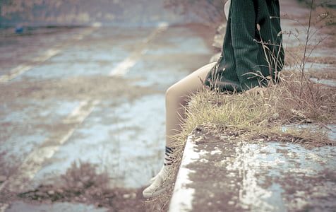 person sitting on concrete bench during daytime thumbnail