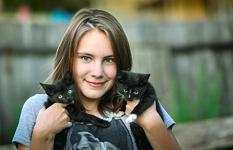 woman holding two black kittens thumbnail