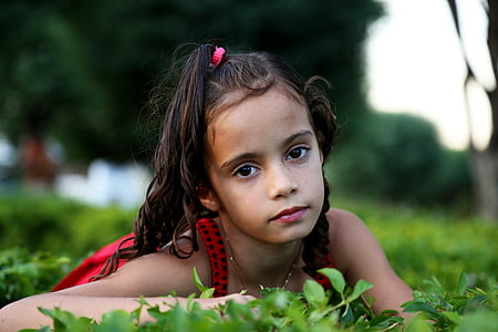 shallow focus photography of girl on grass field during daytime thumbnail
