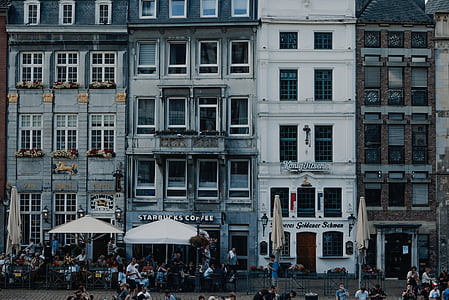 group of people walking in front of concrete building thumbnail