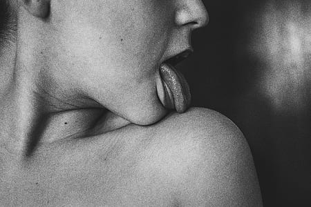 grayscale photography of person licking his/her shoulder thumbnail