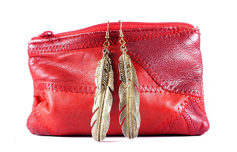 red leather coin purse with pair of gold-colored feather hoop earrings thumbnail