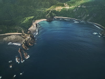 bird's-eye view photo of mountain near body of water thumbnail