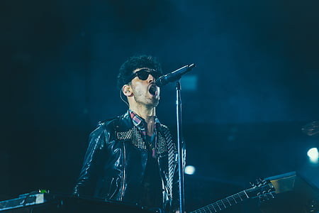 man holding guitar while singing thumbnail