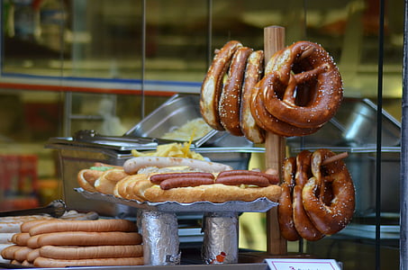 pretzel hanging on brown wooden rack beside hotdog sandwich thumbnail