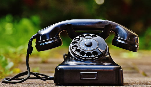 black rotary phone on brown concrete pavement thumbnail