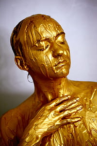 person covered with gold-colored liquid thumbnail