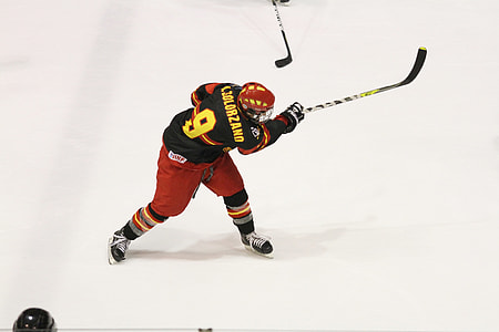 ice hockey player holding black and yellow hockey stick thumbnail