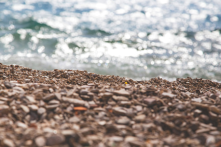 photo of brown sand near sea at daytime thumbnail