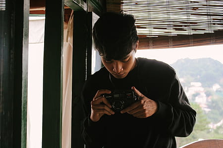 Close-Up Photo of Man Holding Vintage Camera thumbnail