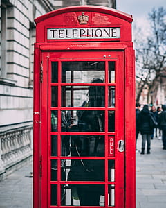 red telephone booth beside building thumbnail