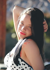 woman with right hand holding hair thumbnail