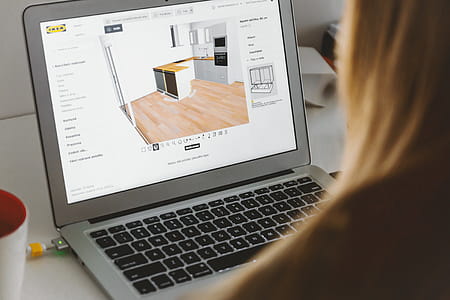 Woman uses 3D planning software for her new kitchen on laptop at home thumbnail