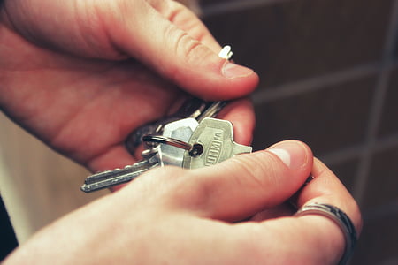 person holding stainless steel keys thumbnail