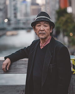 man wearing black bucket hat standing near the fence thumbnail
