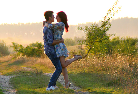 man and woman hugging near grass field thumbnail