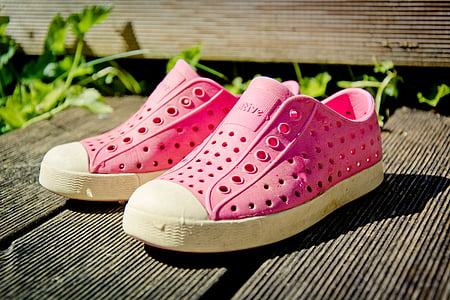 pink slip-on shoes near plants thumbnail