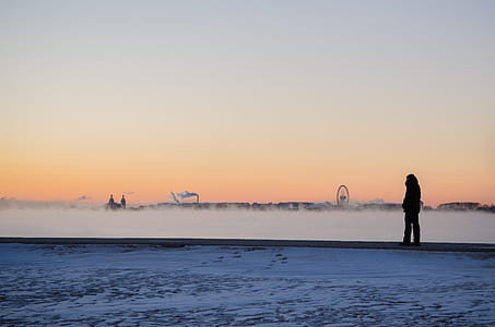 silhouette of person standing near white field at golden hour thumbnail