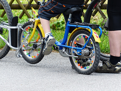 boy riding on blue and yellow bike at daytime thumbnail