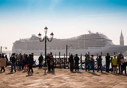 people standing near cruise ship on body of water during daytime thumbnail