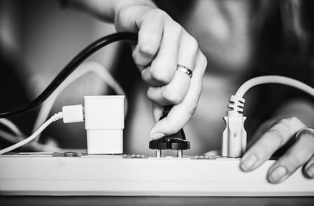 Person Holding Black Cable Wire and Power Strip thumbnail
