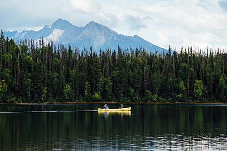 two person riding yellow canoe on calm body of water thumbnail