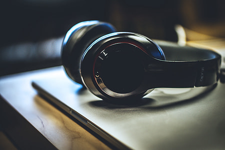 Silver headphones resting on a laptop thumbnail