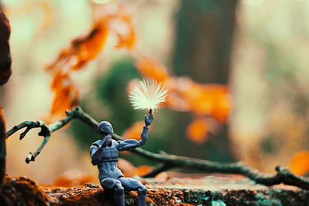 Sitting Gray Action Figure Beside Brown Tree Branch thumbnail