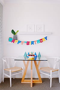 multicolored Happy Birthday banner on white painted wall thumbnail