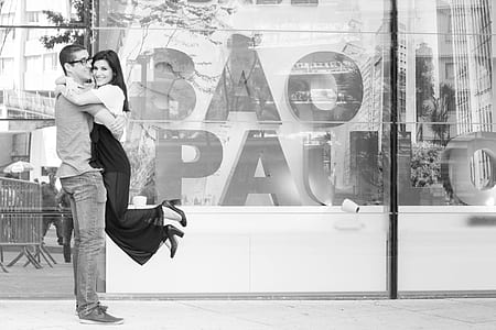 man carrying woman infront of glass wall thumbnail