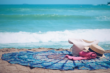 white hats on pink textile near at the ocean thumbnail