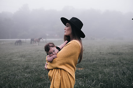 man carrying baby while fogging in fields thumbnail