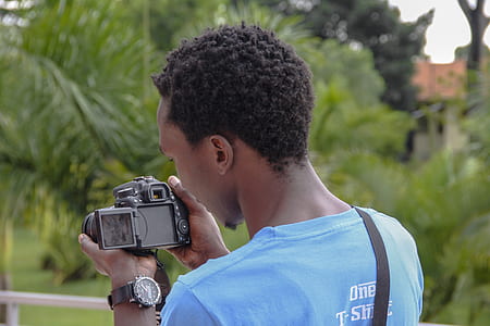 man holding DSLR camera while looking at the pictures thumbnail