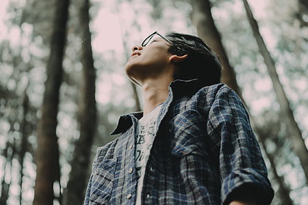 man standing surrounded by trees during daytime thumbnail