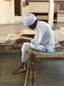 man sitting on charpai bed thumbnail
