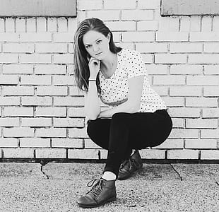 woman sitting beside brick wall thumbnail