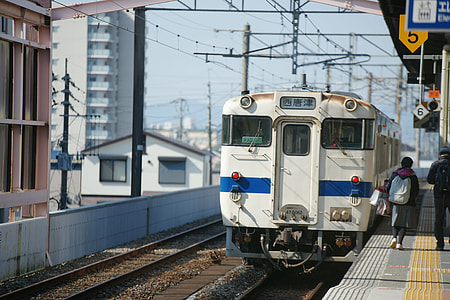 two people walking on rail station near white locomotive train thumbnail