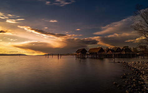 photography of brown cottage on body of water thumbnail